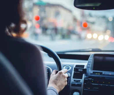 Woman driving car on city street