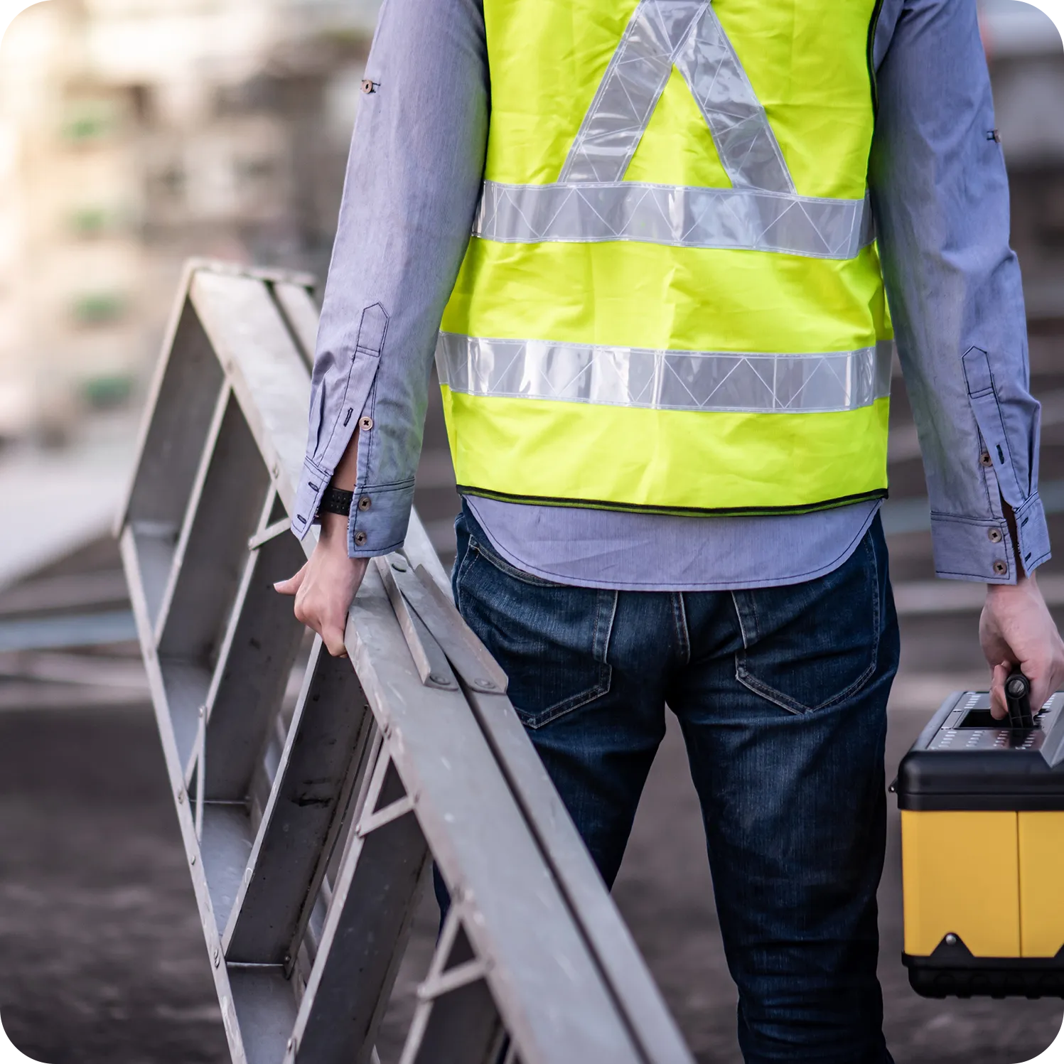 Home services worker carrying a ladder and toolbox while wearing a high-visibility vest.