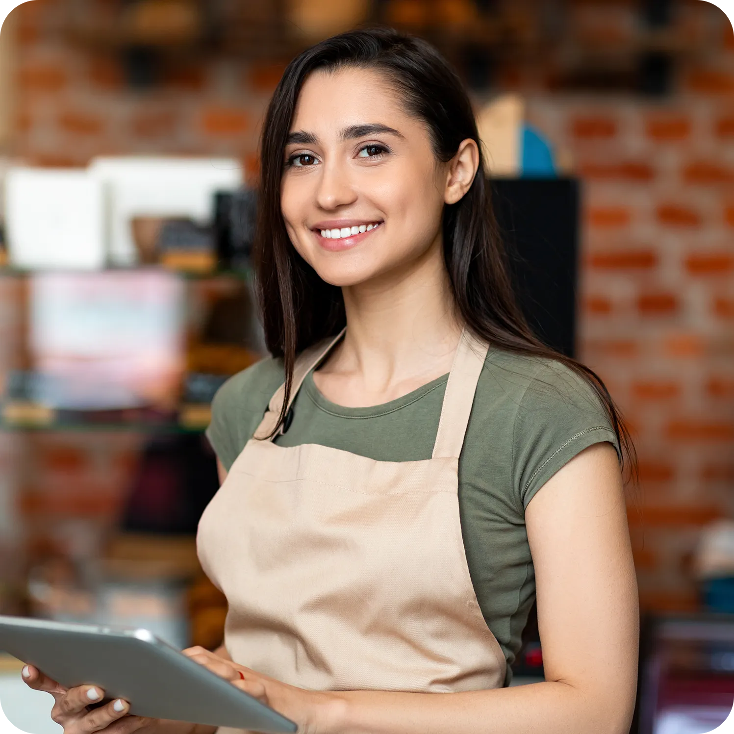 Smiling restaurant worker wearing an apron and holding a tablet.